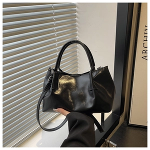 Close-up of black PU leather bucket bag with natural folds and adjustable shoulder strap