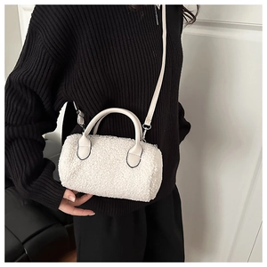 Mini borsa a bauletto bianca in shearling sintetico indossata su maglione nero a maglia