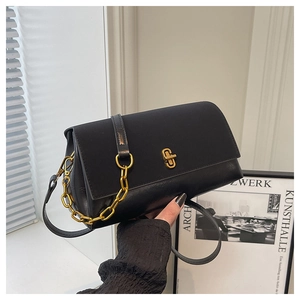 Detail einer schwarzen Umhängetasche aus Leder mit goldenem Drehverschluss und Kette