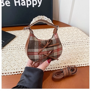 Detail of mini plaid wool handbag with leather bows and lace-trimmed handle