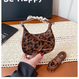 Detail of leopard print crescent bag with leather bows and lace wrapped handle