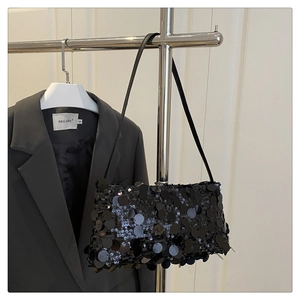 Détail d'un sac à bandoulière à paillettes noires montrant la texture brillante