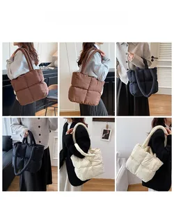 Quilted down tote bag detail showing padded grid design and thick cylindrical handles