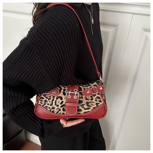 Detail of leopard print shoulder bag with red leather straps and buckle embellishments