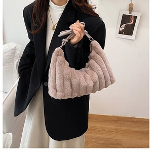 Detail of plush underarm bag showing soft faux fur texture and knotted handle design