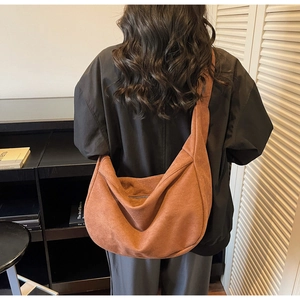 Close-up of caramel brown tote bag with wide strap and smooth suede-like texture
