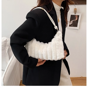 Detail of white plush hobo bag featuring soft faux fur textures and striped quilting