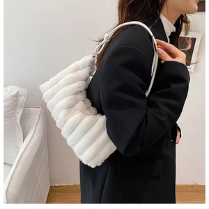 Detail view of the soft white plush texture and horizontal pleated design on the shoulder bag