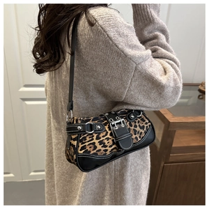 Detailed shot of leopard print shoulder bag with silver buckles and leather trim details