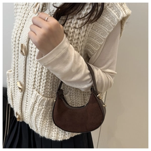Borsa a mano in pelle scamosciata marrone scuro indossata per un look vintage