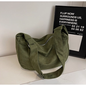 Detail view of olive green suede hobo bag with wide strap and silver metal zipper