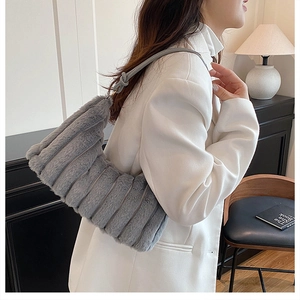 Close-up of gray faux fur shoulder bag with vertical quilted texture and knotted strap