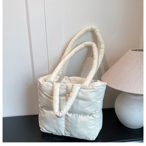 Detailed shot of white quilted puffer tote bag with dual handles and puffy texture