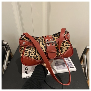 Detailed close-up of leopard print shoulder bag with silver buckle and stud hardware