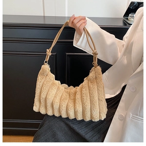 Detailed close-up of pleated beige faux fur shoulder bag with knotted strap detail