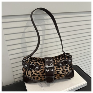 Close-up of leopard print fabric with brown leather straps and silver metal buckle detail
