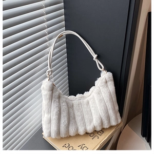 Detail of white plush shoulder bag featuring vertical wavy pleats and leather handle