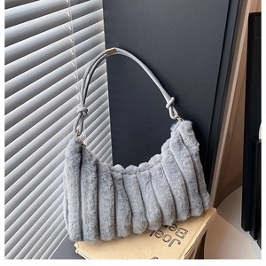 Detail of grey faux fur shoulder bag with textured stripes and decorative knotted handle