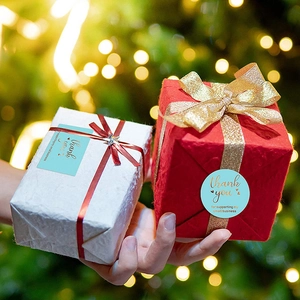 Mint green and gold foil Thank You stickers on gift boxes with warm bokeh lights