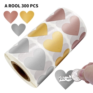 Close-up of heart scratch stickers showing rose gold surface being scratched off with a coin