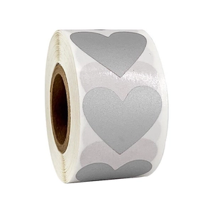 Detail of silver heart-shaped scratch stickers on a roll for DIY and gift labels