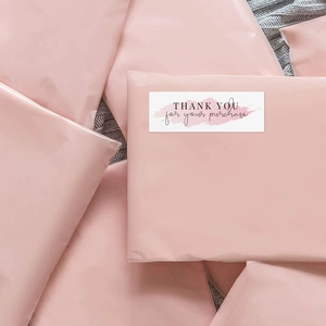 Pink waterproof poly mailers with white rectangular Thank You stickers for shipping