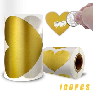 Macro shot of 100pcs golden heart scratch stickers with a coin revealing text
