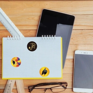 2022 Graduation stickers set featuring Congrats Grad designs on grid notebook and desk