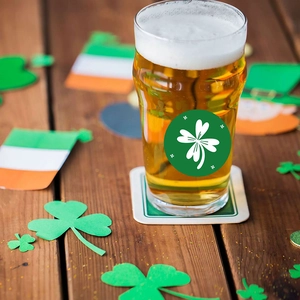 Boccale da birra di San Patrizio con adesivo trifoglio verde su tavolo festivo