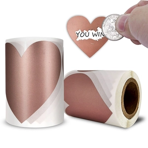 Rose gold heart scratch-off stickers on rolls showing a scraped surface revealing text