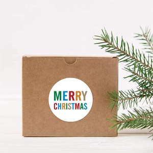 Pegatina redonda de Feliz Navidad en caja de regalo de papel kraft con ramas de pino