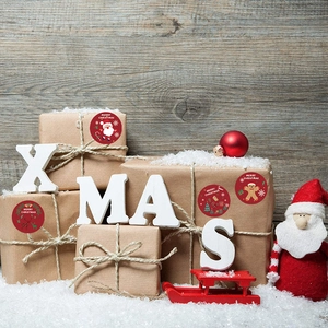 Red Merry Christmas stickers with Santa and reindeer on a kraft paper gift box decoration