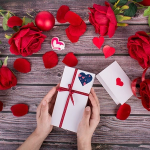 Valentine's Day heart stickers and red ribbon on gift box with roses background