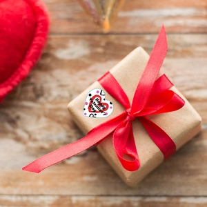 Autocollants de cœur de Saint-Valentin sur boîte cadeau avec rubans rouges élégants