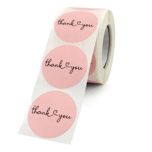 Pink round thank you labels on a roll with elegant heart design for gift packaging