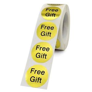 Glossy gold round free gift stickers with black lettering on a roll for packaging
