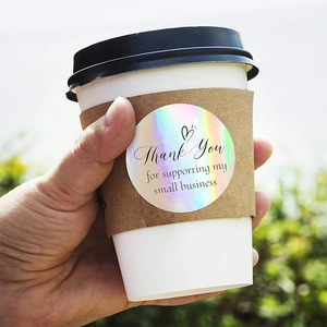 Macro shot of a holographic Thank You sticker applied to a coffee cup sleeve