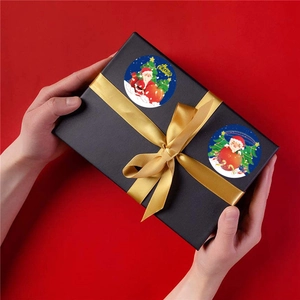 Roll of Christmas Merry Christmas stickers with Santa and tree motifs on gift box