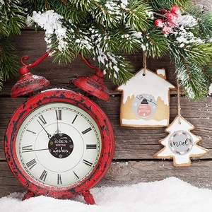 Vintage red Christmas clock and holiday ornaments on snowy wood backdrop decorations