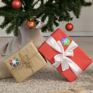 Holographic snowflake Christmas stickers on gift boxes under a decorated Xmas tree