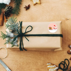 Primo piano di un adesivo natalizio con Babbo Natale su una confezione regalo kraft