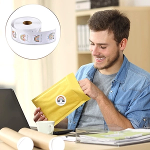 Rainbow bridge Thank You sticker roll being applied to a yellow mailing envelope