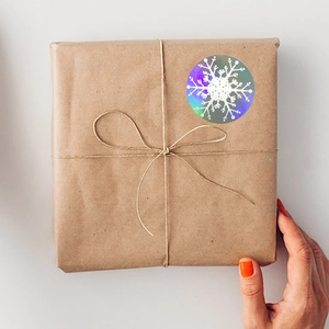 Holographic laser snowflake Christmas stickers on brown kraft paper gift packaging