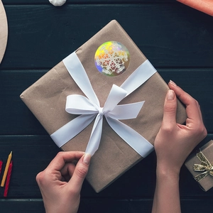 Holographic snowflake Merry Christmas sticker on gift box with laser rainbow effect
