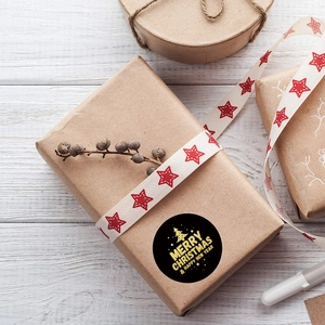 Black Merry Christmas and Happy New Year stickers with gold foil on gift box wrapping