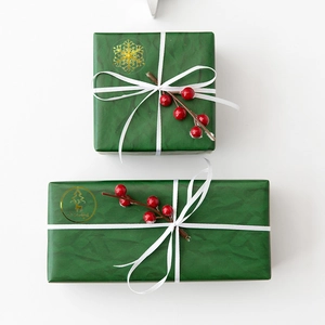 Transparent gold Christmas stickers with snowflakes on green gift boxes with ribbons