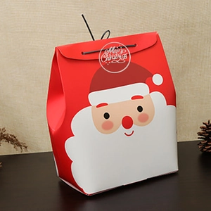Christmas gift bag with Santa Claus print and Merry Christmas text on dark wood background