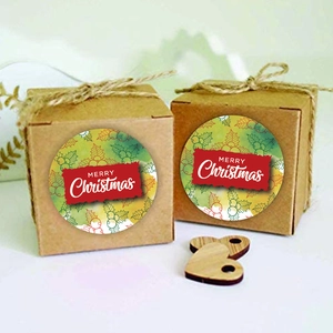 Dettaglio di adesivi Merry Christmas su scatole regalo in kraft con motivi di agrifoglio