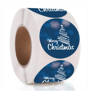 Primo piano di un rotolo di adesivi Buon Natale blu scuro con disegni di alberi bianchi