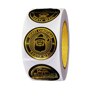 Roll of black and gold Merry Christmas stickers featuring Santa Claus and gift designs